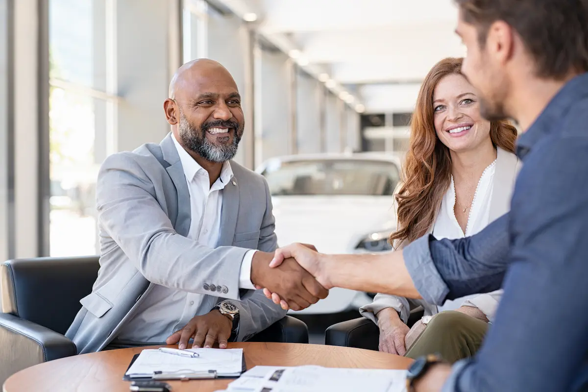 Couple buying a new car at the car dealership
